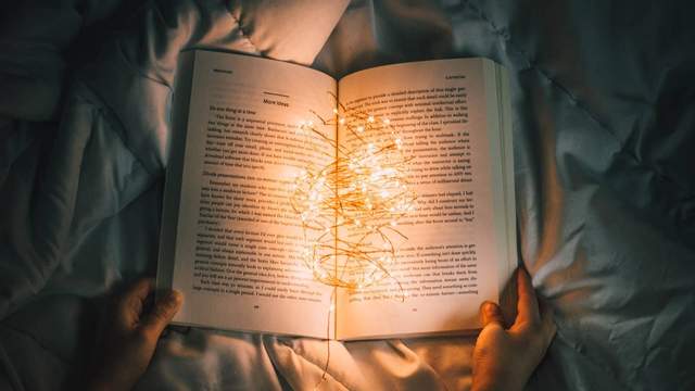 Open book with light streaming through pages, evoking storytelling