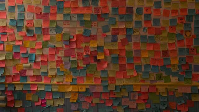 A wall densely covered in colourful sticky notes